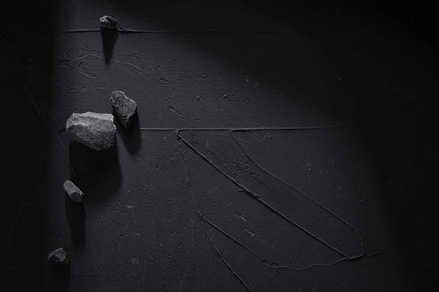 Concrete black background with stones